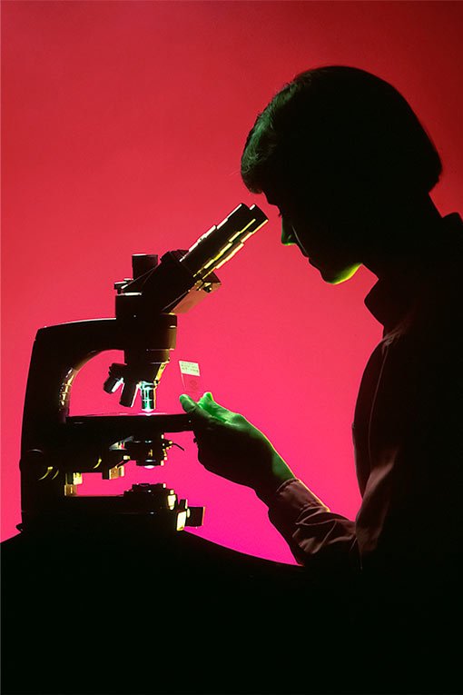 Mulher analisando amostra no microscópio