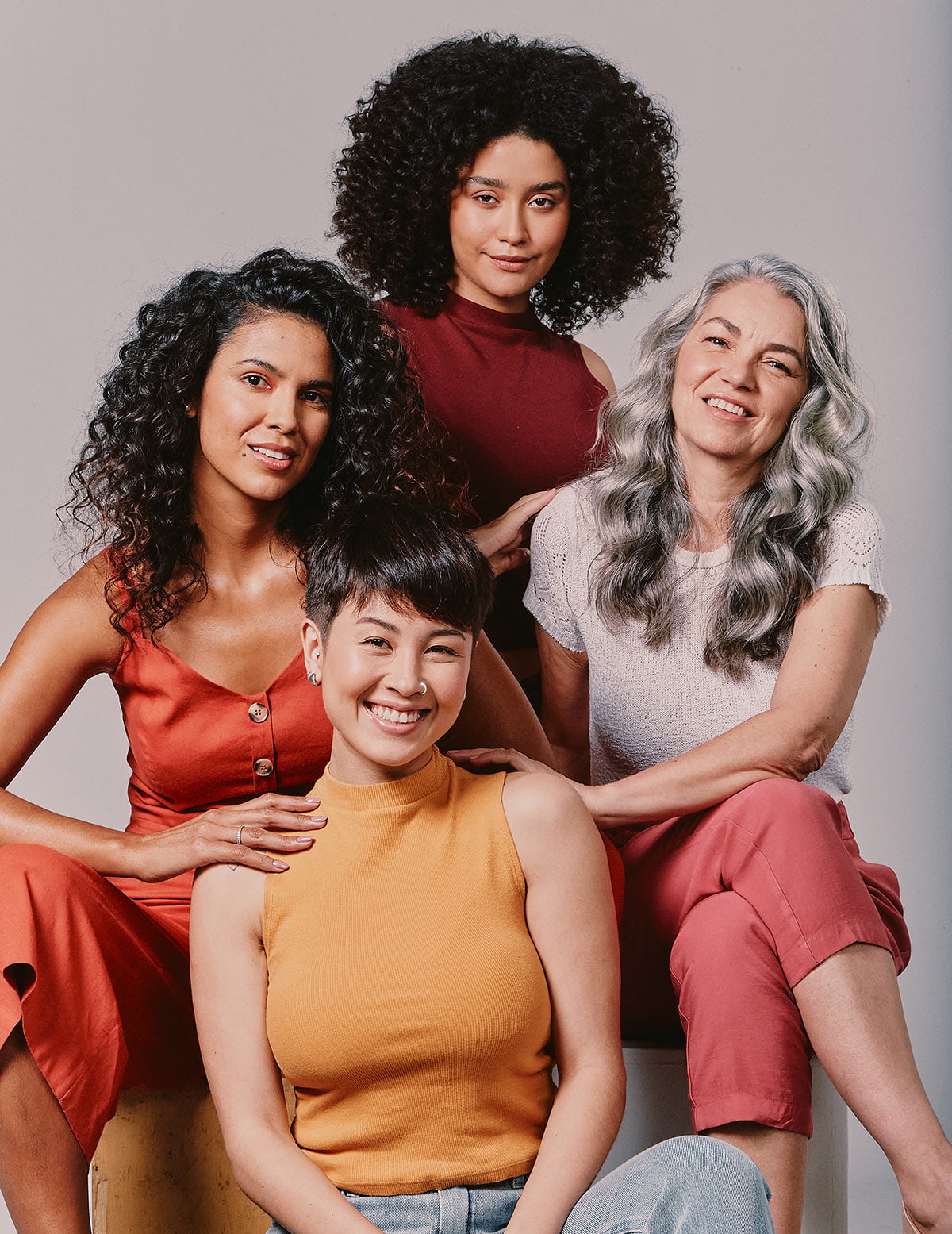 Quatro mulheres com diferentes cabelos sentadas